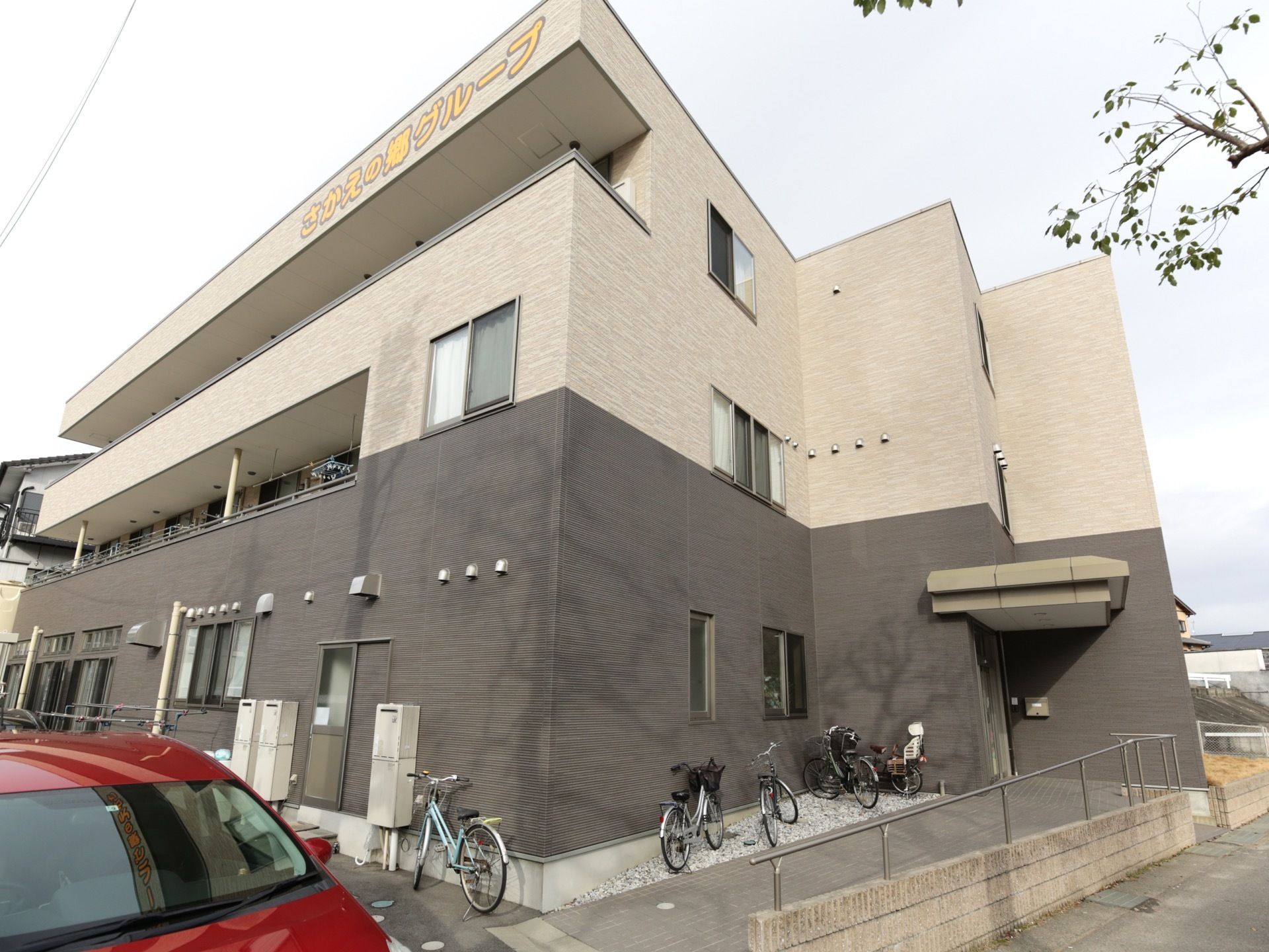 落ち着いた色合いのツートンカラーの外装で、おしゃれな集合住宅のような見た目。居室はベランダに面していて、日当たりが良い。