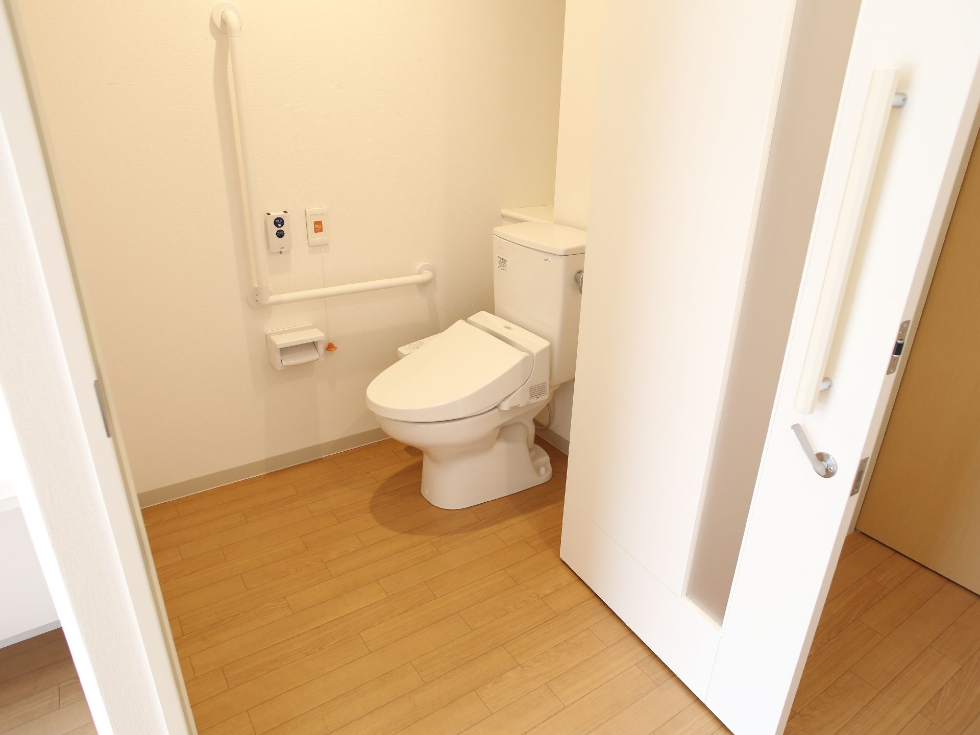 バリアフリー設計車椅子対応トイレは、壁に非常用放送設備、緊急ボタンが設置され、暖房洗浄機能が付いている。