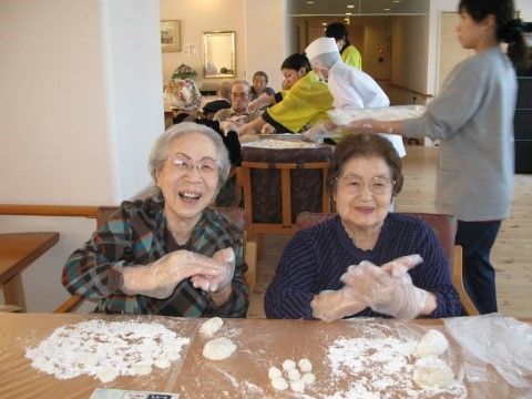 つきたてのお餅をご友人と楽しそうに丸めているご入居者様