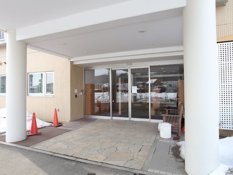 玄関の入り口には屋根が設置され雨の日でも安心。ベンチも置かれているので休憩も可能。自動ドアは両開きでゆとりある作り。