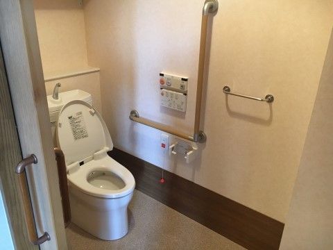 トイレは洗浄機能を完備している。壁にはスタッフを呼び出せるボタンが設置されており、入居者様にも安心してご利用して頂ける。