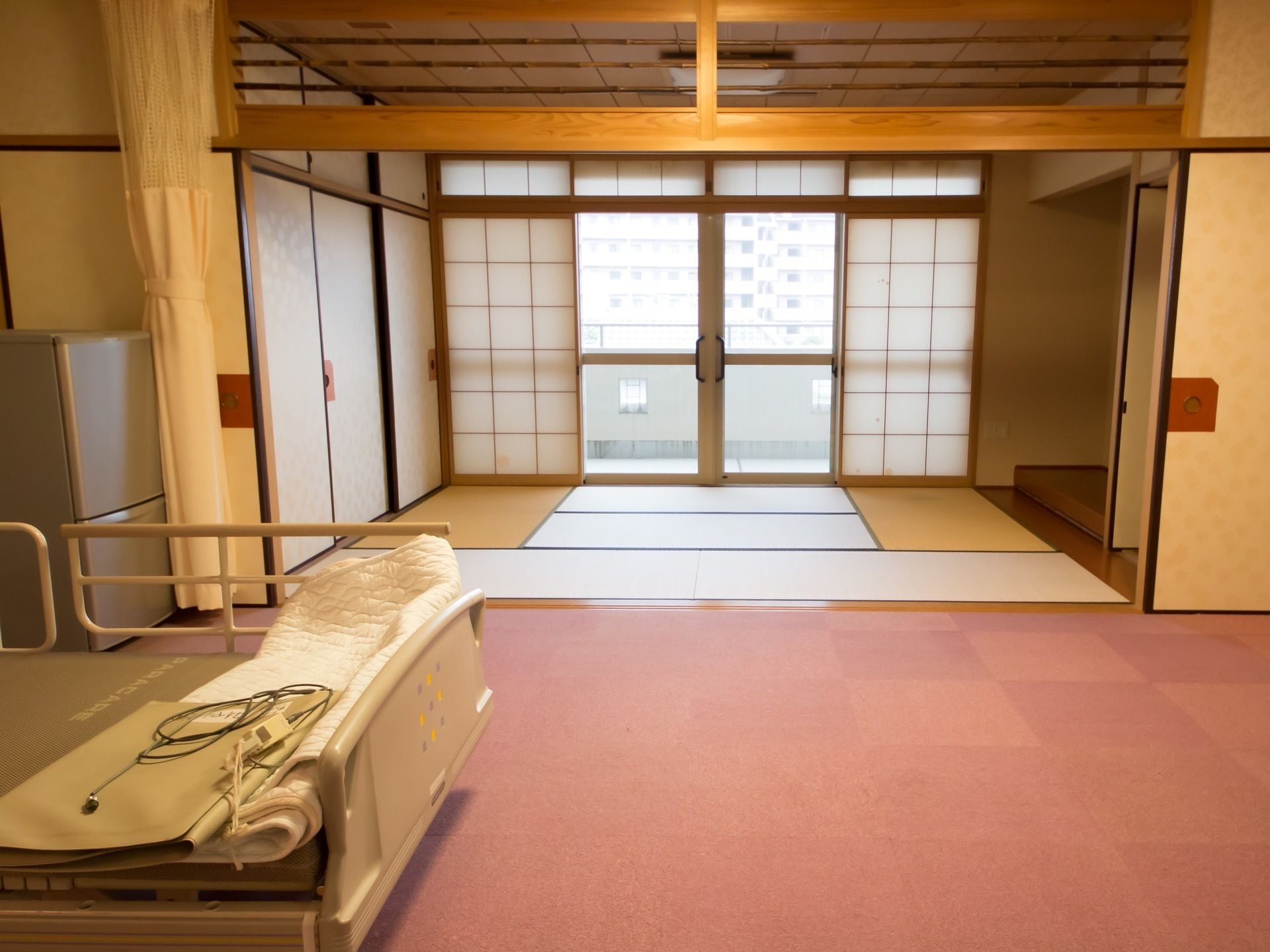 床の間や欄間が施された居室には、袋戸棚や押入れが完備され、襖で間仕切りできるカーペット敷きのスペースには、介護用ベッドが設置されている。