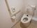 トイレは白を基調とし、明るい雰囲気にレイアウトされている。壁には手すりと緊急通報装置が設置されている。