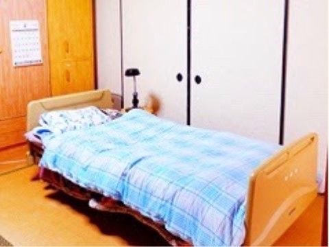 落ち着きある和風タイプの居室がある。畳の上にベッドを設置しており、すぐに明かりが灯せるようスタンドライトも置かれている。