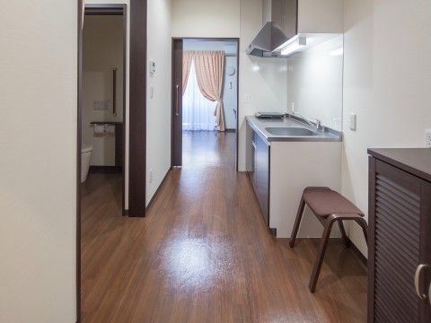 白を基調したシンプルな居室である。備え付けのキッチンは最新式で、電磁調理器が完備されているので火の後始末の心配がない。