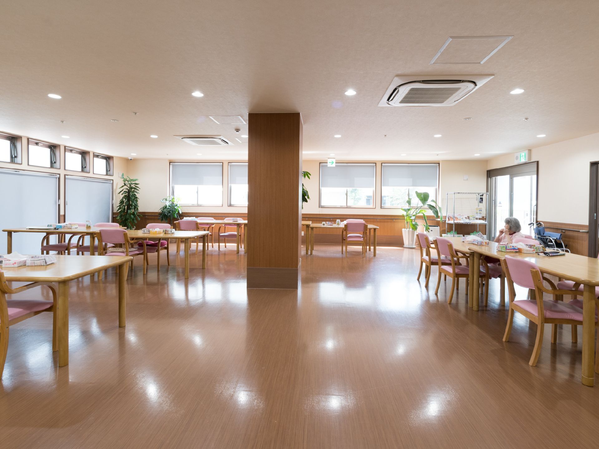 窓がたくさんあり明るい雰囲気である。床はフローリングで白と木目調の壁紙を使用している。中央に柱がある。