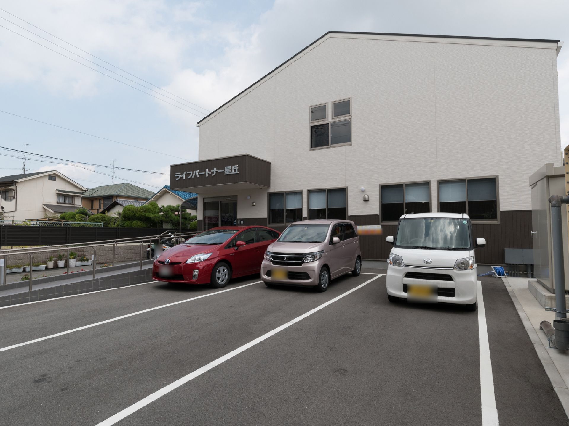 施設の前には数台の車が停められるアスファルトの駐車場がある。横に３台、縦に数台縦列駐車で置くようになっている。