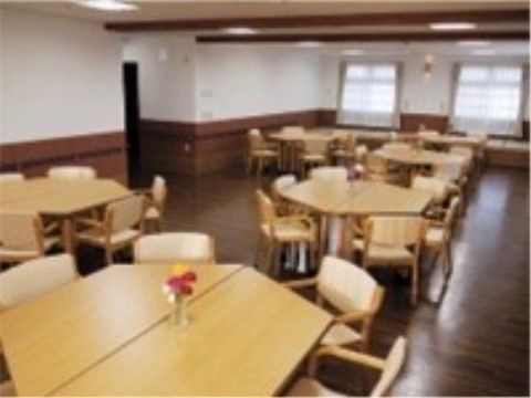 ６角形のテーブルを囲むように椅子が置かれた６人がけのテーブル。テーブルの中央には、色鮮やかな一輪挿しが置かれている。