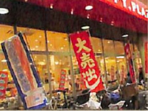 スーパーマーケットが近所にあり、食品などの買い物をしていくことができる。店の手前には幟が立っている。