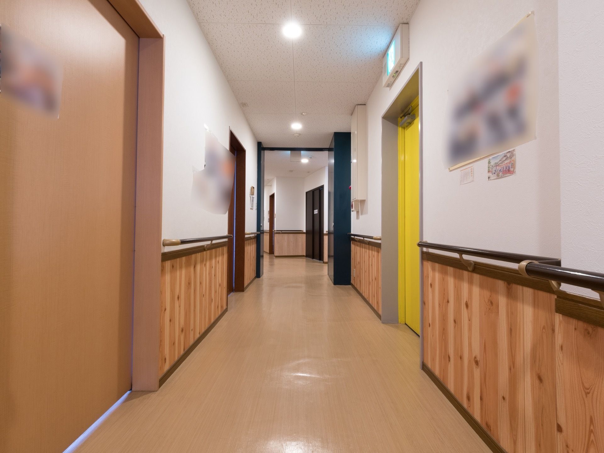通路の壁側には手すりが取り付けられている。右側には黄色い扉があり、非常出口になっている。上側には非常出口誘導灯がある。