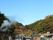 小高い山の風景である。山の手前には民家が並んでおり、とても開放感がある。民家の左側には白い湯けむりが見える。