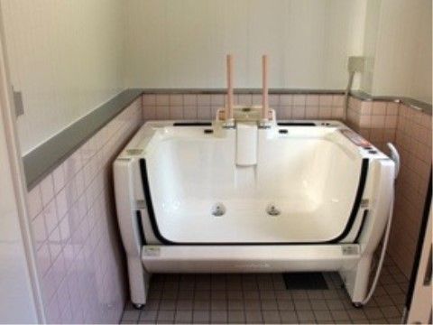 誰でも楽に入浴できるタイプの介護浴槽がある。浴室には介護浴槽の高さまでピンク色のタイルが張られている。