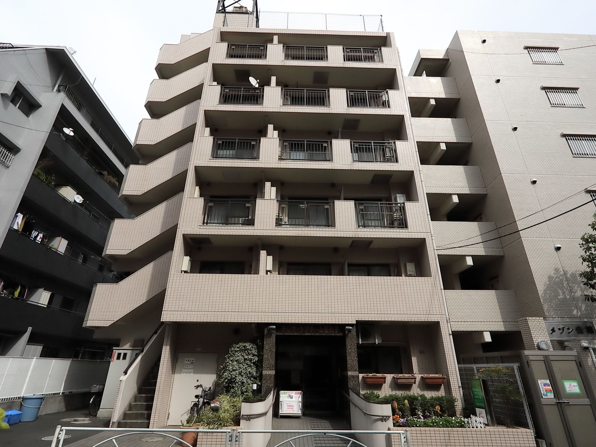 マンションのような外観の施設である。歩道から玄関へはゆるやかなスロープになっていて、両側に手すりが設置されている。