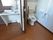 居室内には、広々としたトイレとその隣りに簡易洗面台が設置されている。扉はダークブラウンの引戸が取りつけられている。
