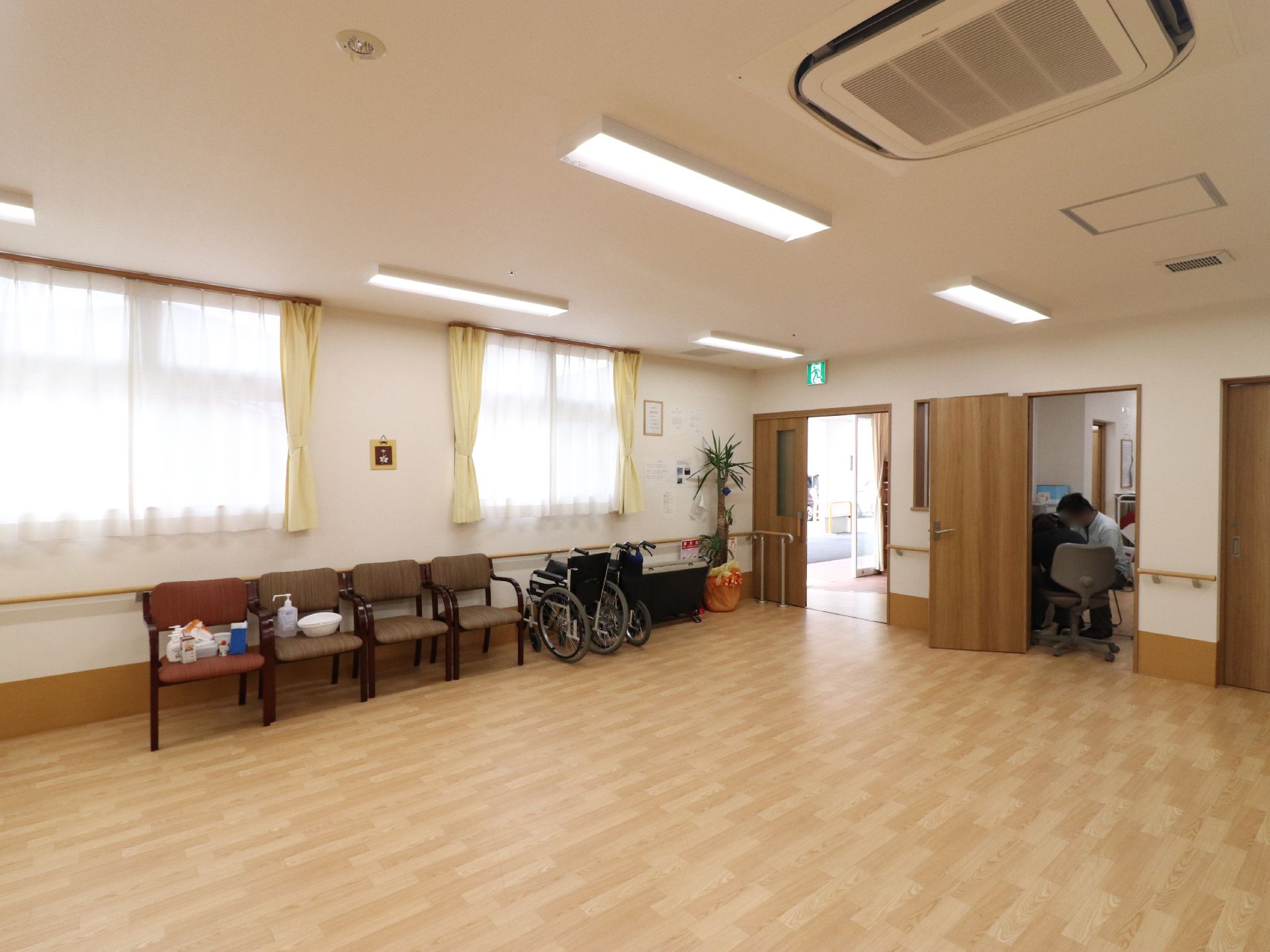 広々としたスペースのフロアには椅子が4脚と車椅子が置かれている。壁には手すりが取り付けられているので、歩行訓練にも適している。