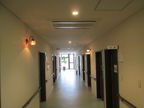 廊下は、雰囲気たっぷりの照明の光に照らされている。共用の部屋の扉の前には、部屋名が明記されたプレートが掲示されている。