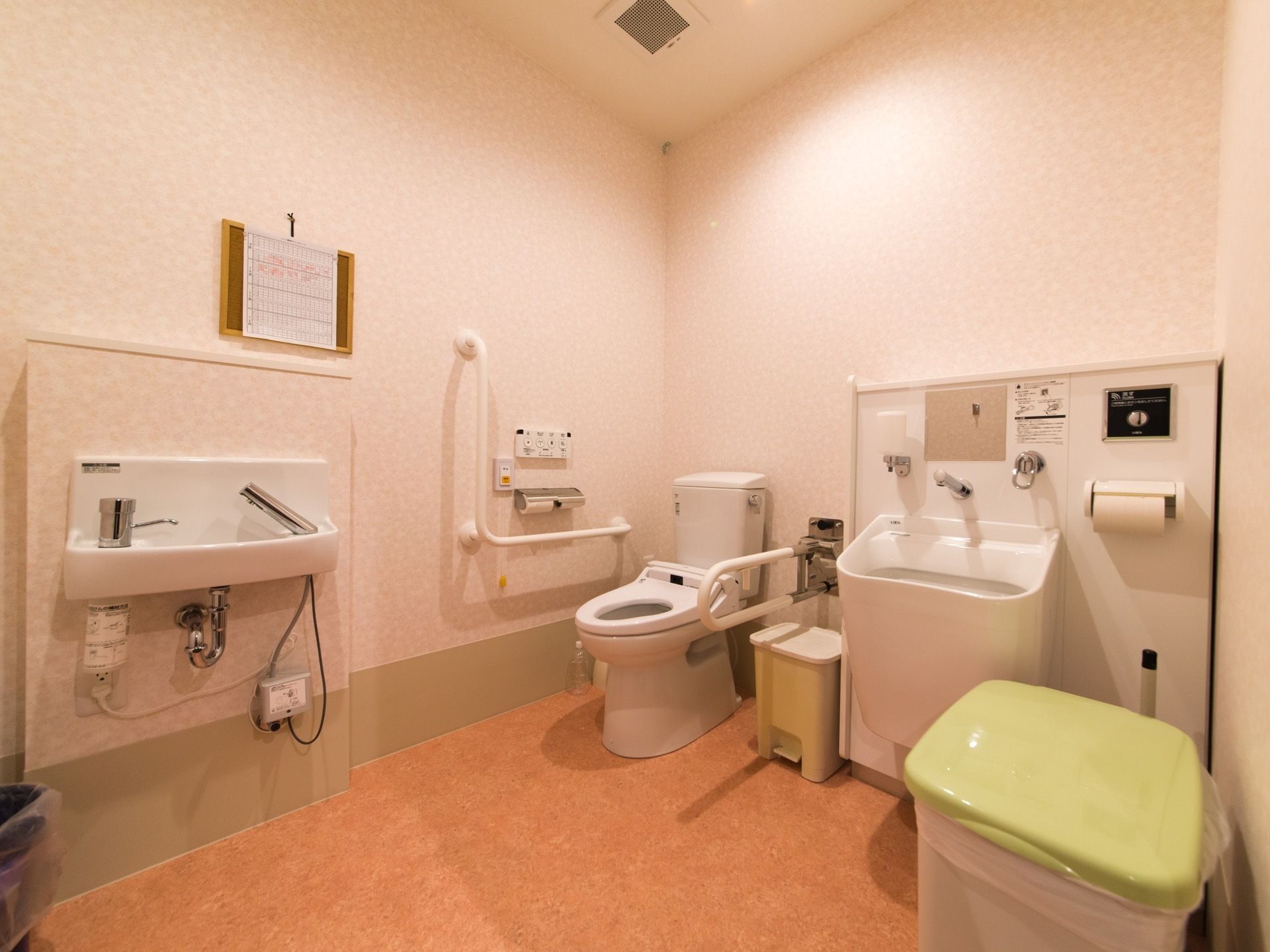トイレ内に、洋式便器と手洗い場、オストメイト用トイレが設置されている。壁に手すりとナースコールが取り付けられている。
