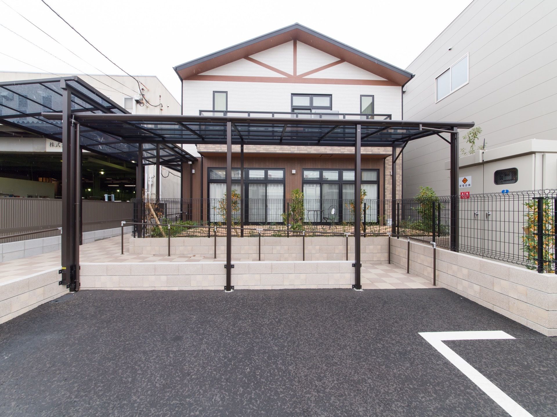 施設は2階建てで、建物前にフェンスで囲まれた庭がある。駐車場から玄関へ続く通路があり、屋根が付いている。