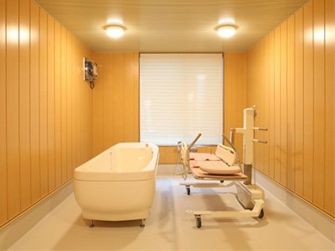 介護入浴機器が設置された機械浴室である。寝たままで入浴ができるので、入居者様の身体への負担軽減になりご安心いただける。