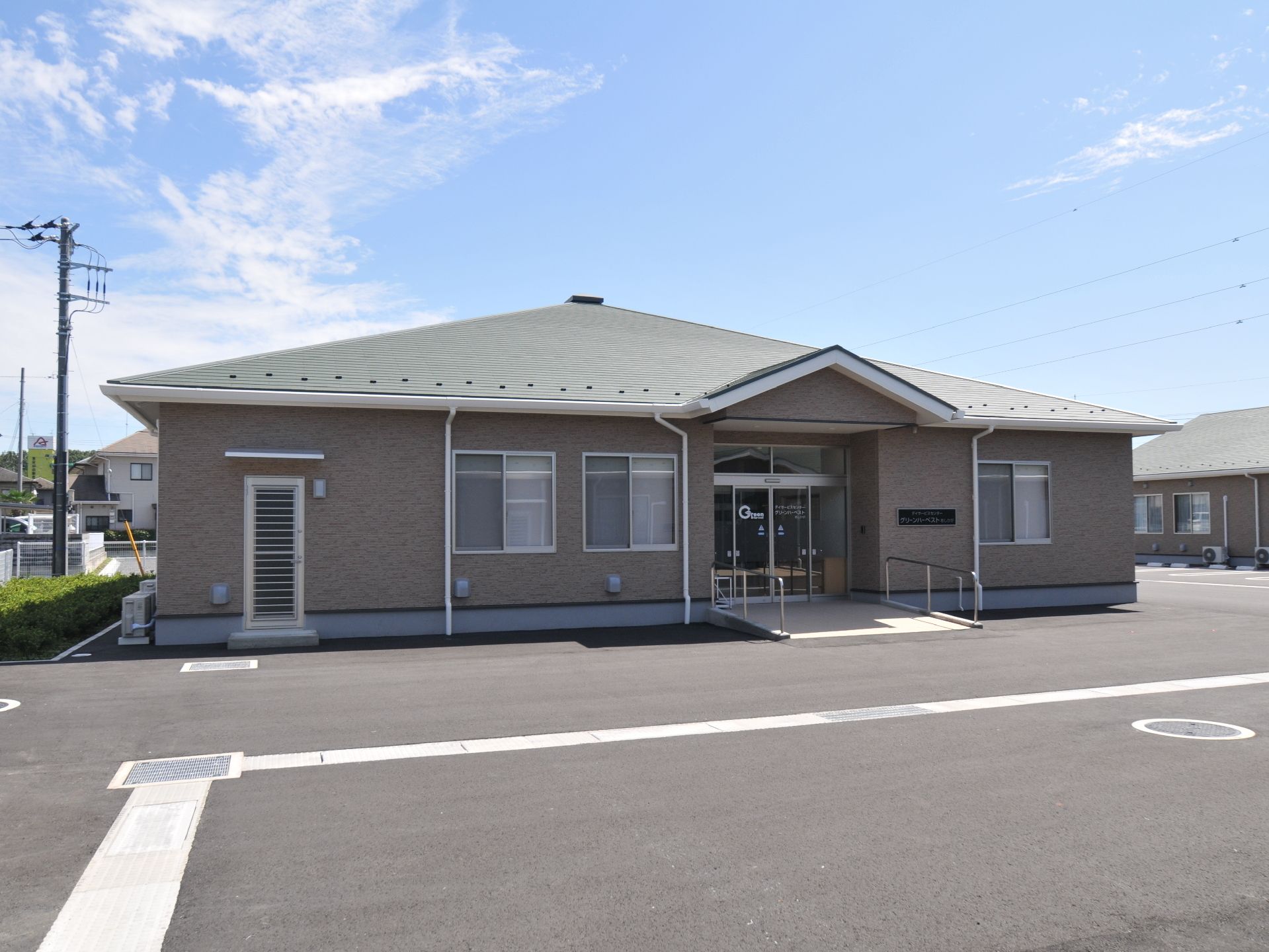 広く緩やかな傾斜でできている、1階建ての施設の玄関