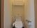 個室トイレは間接照明の柔らかい明かりになっています。ウォシュレットも付いているシンプルなトイレです。