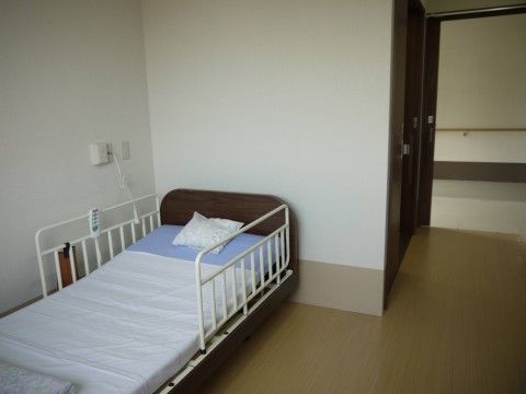 白を基調とした部屋に介護用ベッドが設置されている。そして居室の入口はスライド式の扉なので、車椅子でもスムーズに入室することができる。