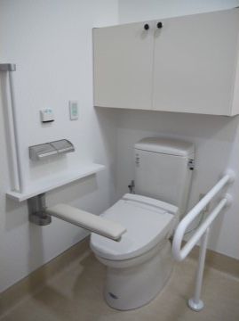 洋式の便器の周りには、手すりなどが設置されており、立ち上がる時にスムーズに動作ができるように配慮。また白を基調としており清潔感がある。