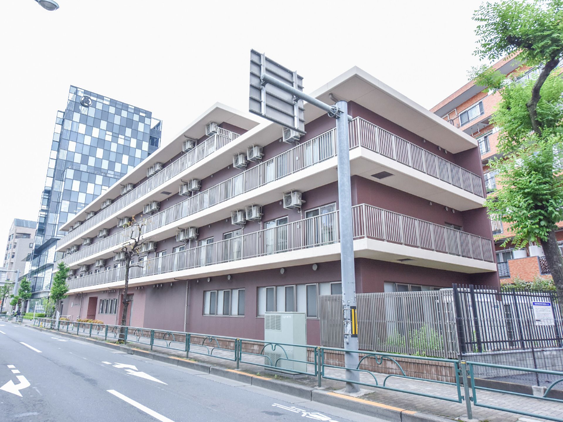 道路に面して建つ、あずき色と白のツートンで塗られた施設