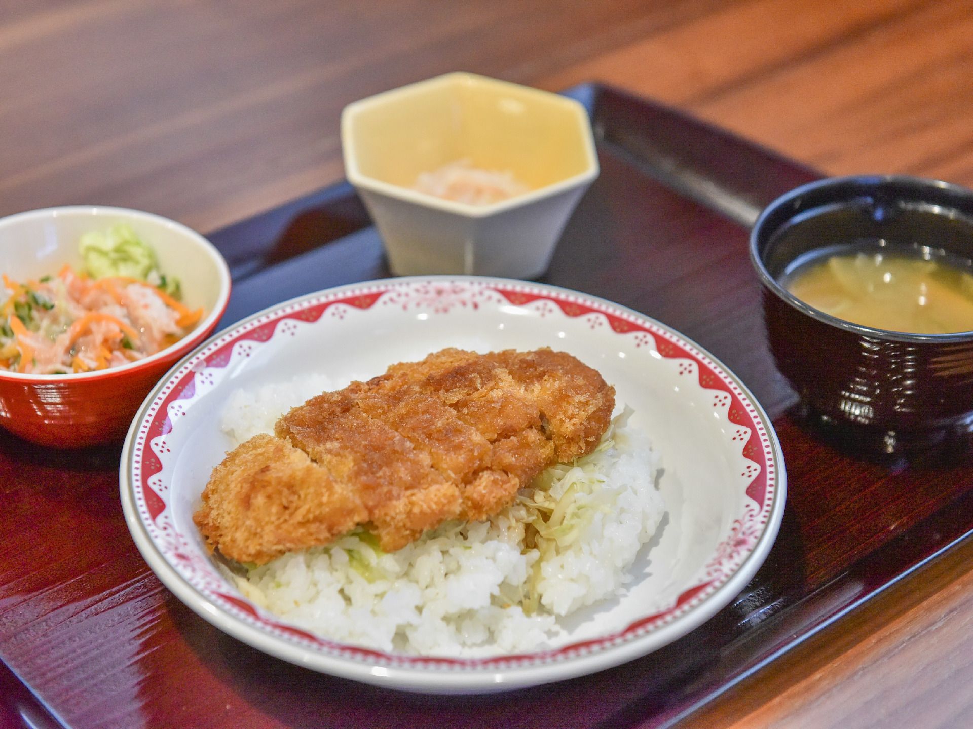 介護施設の食事とは思えない、大きなカツを中心に据えたメニュー。カツと白米の間にはソースのしみたキャベツが挟まる。