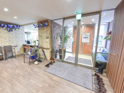 来館者を迎える受付のカウンターが設置されており、高級そうな壁紙の天井付近はアジサイのような造花で飾り立てられている。