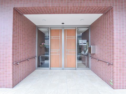郵便受けと手すりの設置された正面玄関口。ドアはよくあるガラス張りではなく木目調の目隠しタイプになっている。