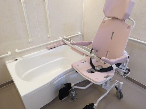 介護用の椅子をご用意した浴槽で快適なひと時を過ごすことができる。手すりを配置し、どなたでもゆっくりと入浴することができる。