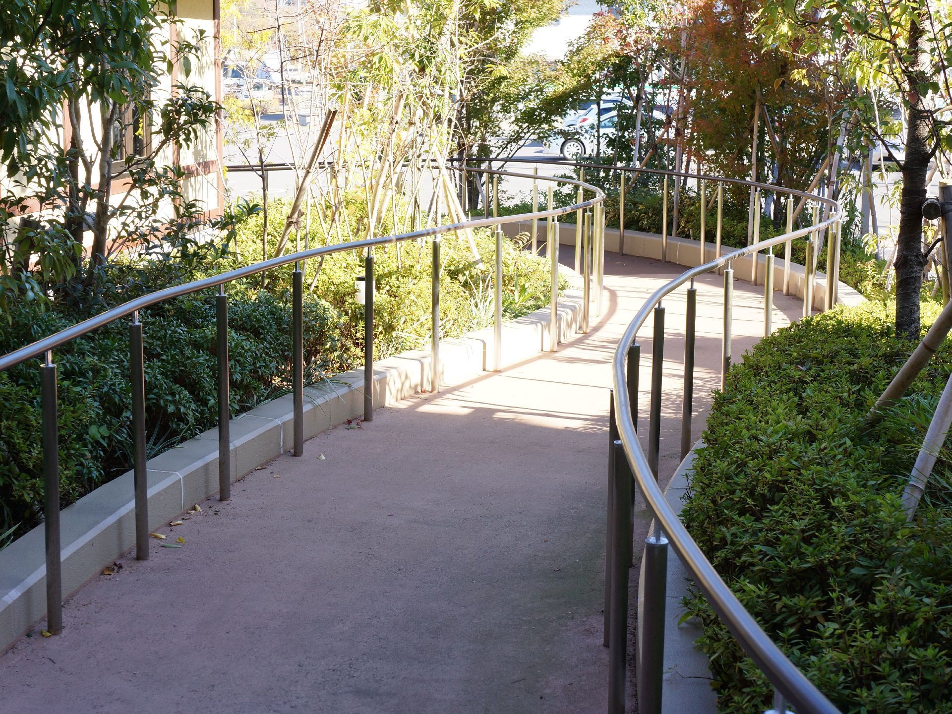 両サイドに花壇があるプロムナードには、手すりがもうけてあるので、天気の良い日は歩行訓練も兼ねて入居者様が散歩を楽しむことができる。