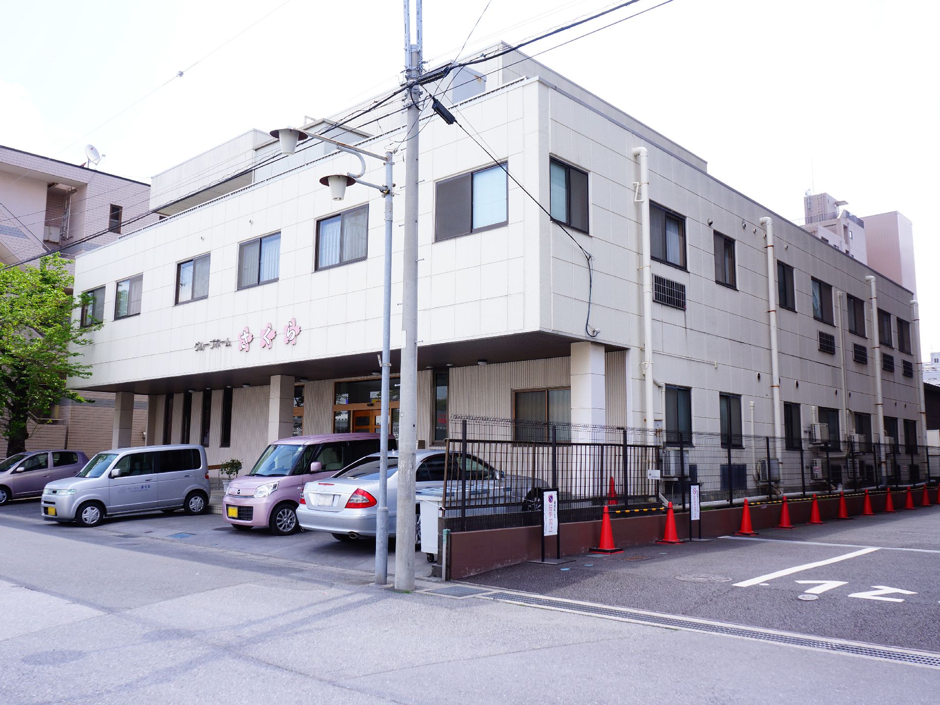 施設は道路に面した2階建ての建物。前面には駐車スペースが設けられている。2階の壁部分に施設名が大きく表示されている。