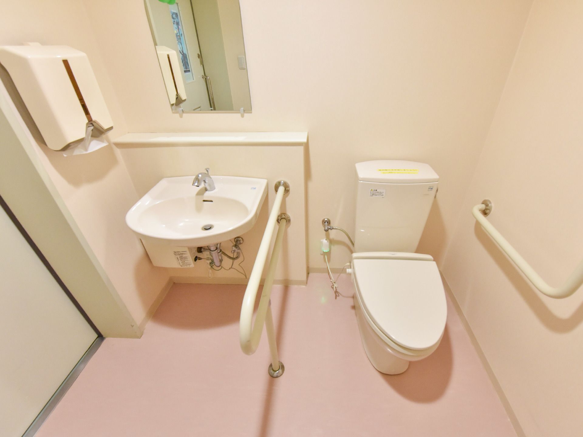 洋式トイレの中は、便器と手洗い場があり、その周りにはスペースが設けられている。車椅子での入室も可能。