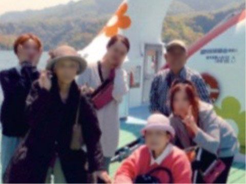 緑豊かな湖畔でカメラに向かってポーズをとる６人の男女