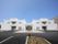 きれいに舗装された駐車スペースの向こうに、白い屋敷のような建物が建っている。エントランスを挟んで、左右対称の外観である。