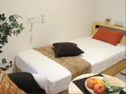 木調のベッドの脇にナースコールなどが備え付けられた部屋
