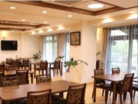 食堂には、背もたれに上品な柄がある椅子を置いている。窓際では間接照明を用いて、オレンジがかった光で優しく照らしている。