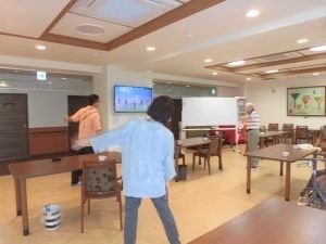 テレビを見ながら入居者とスタッフが体操をしている
