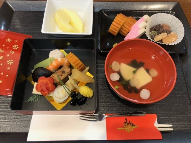 海老や数の子や野菜の煮物、たまご焼きやかまぼこ、吸い物とリンゴのデザートのセット