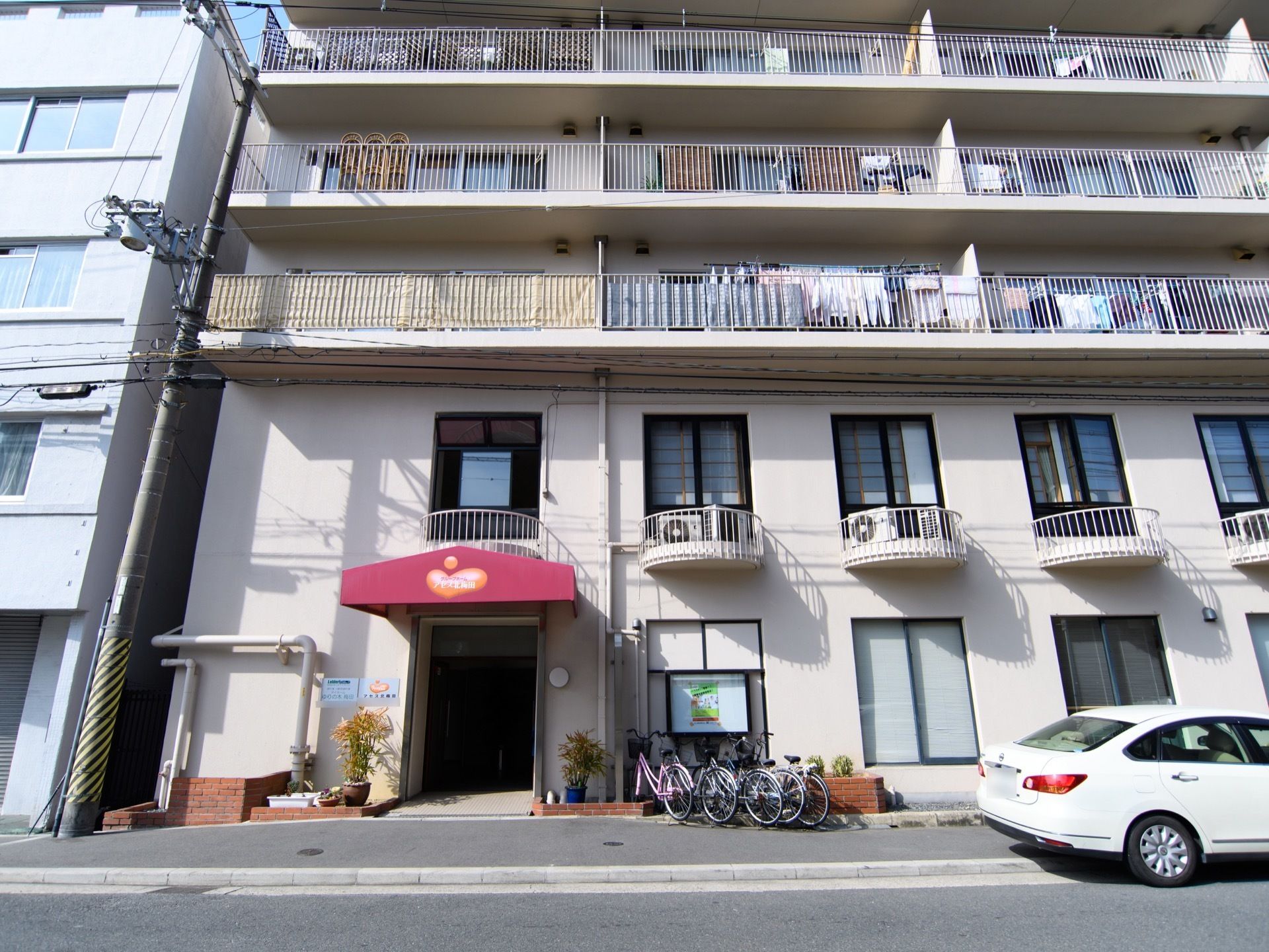 一般的なマンションのような外観になっている。ハーフサークル形のバルコニー部分には、エアコンの室外機が置いてある。