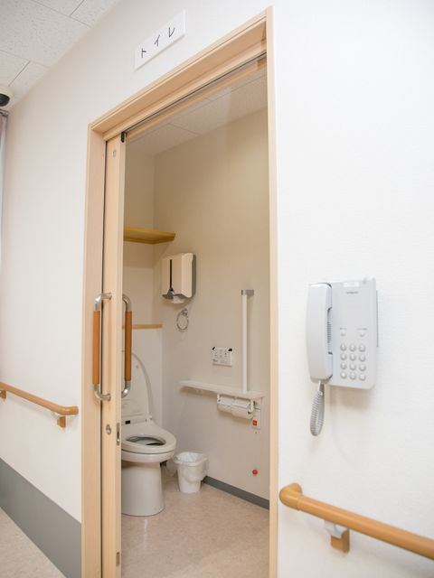 入所者が出入りしやすいよう、トイレのドアはスライド式が採用されている。室内には手すりもあり安心して利用できる。