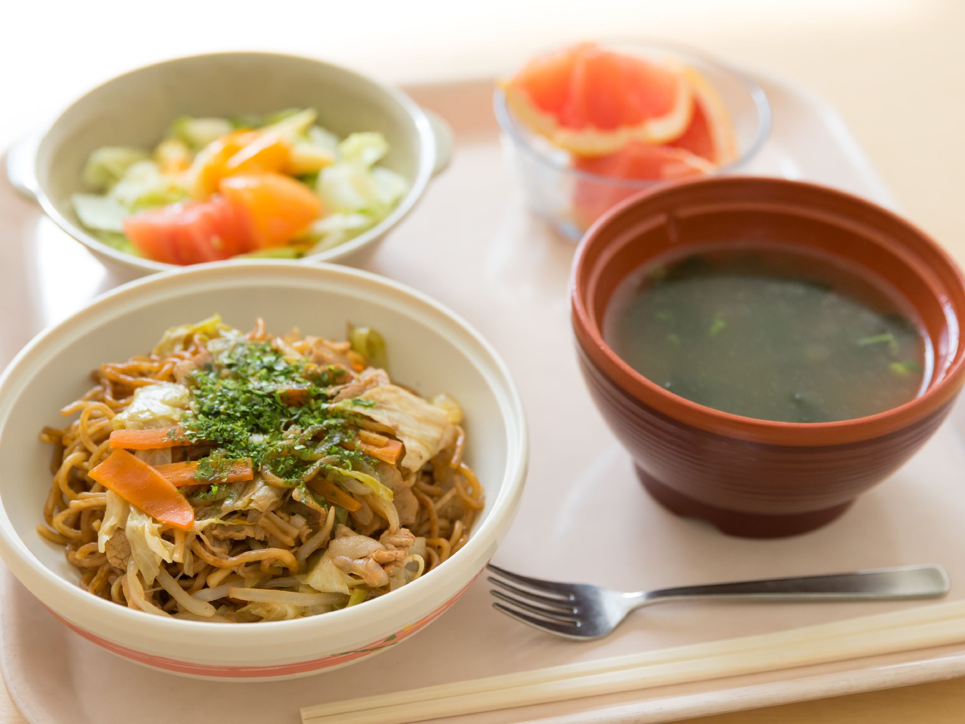 具材たっぷりの焼きそばに汁物とサラダとデザートを添えた食事