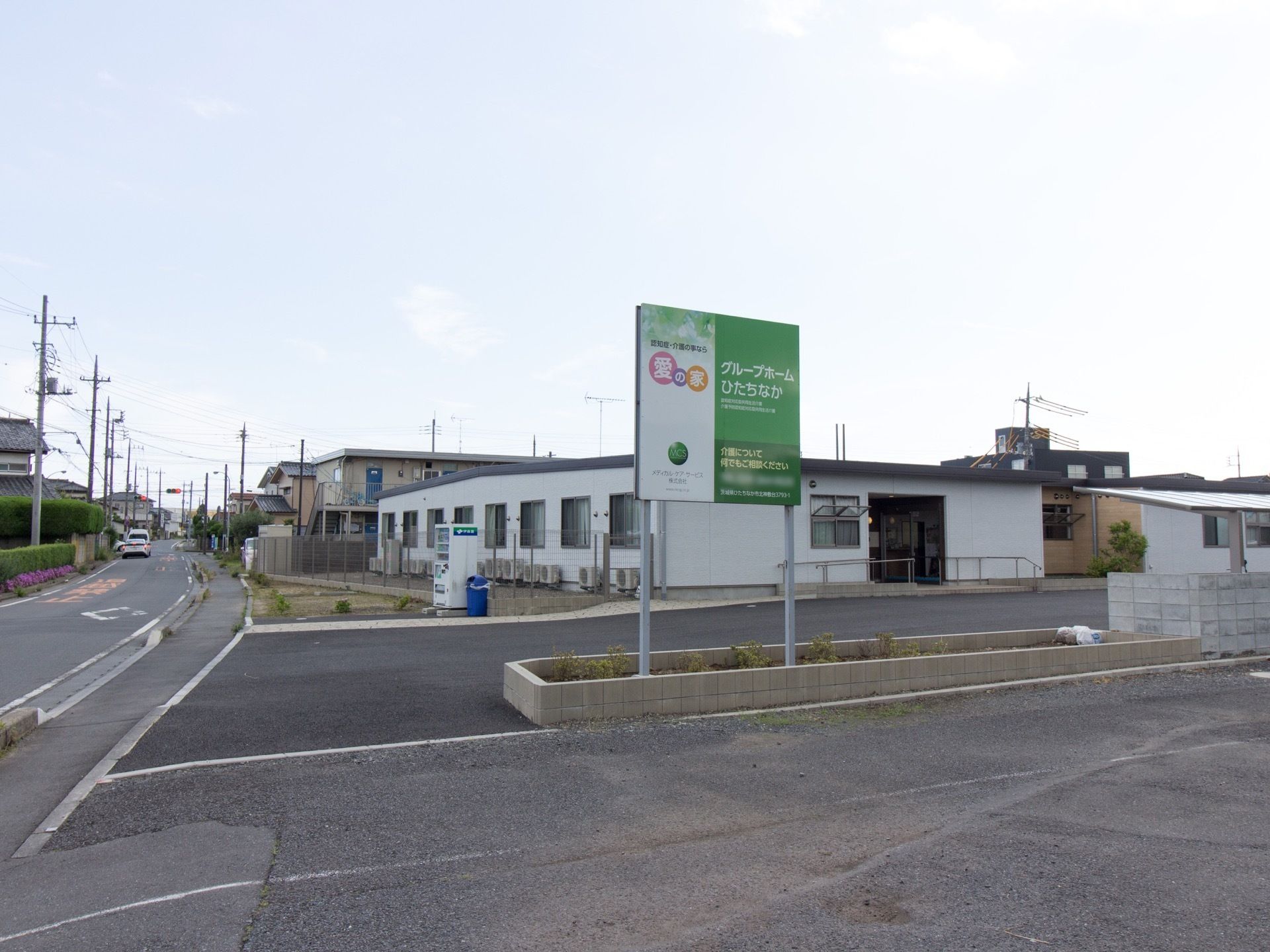 道路に面した平屋建ての施設である。一目につくように大きな看板が立てられている。周りには高い建物がない。