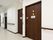 建具は濃いめのブラウンに施された、落ち着いたデザイン。通路の途中に共同のトイレがある。手すりもある。