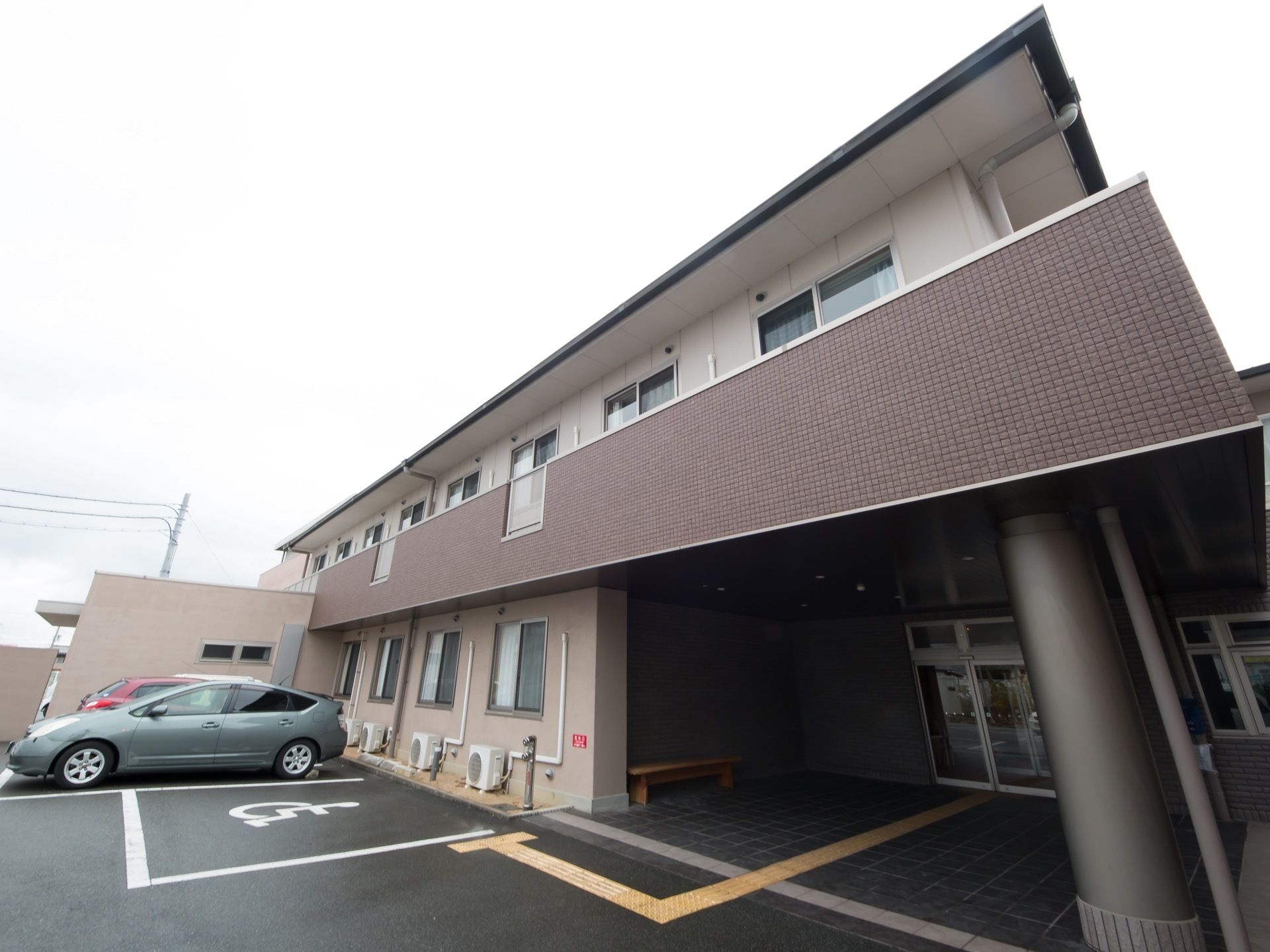施設は2階建てで、白色とグレーで統一された外観となっている。入口には大きな屋根があり、木造のベンチも置かれている。