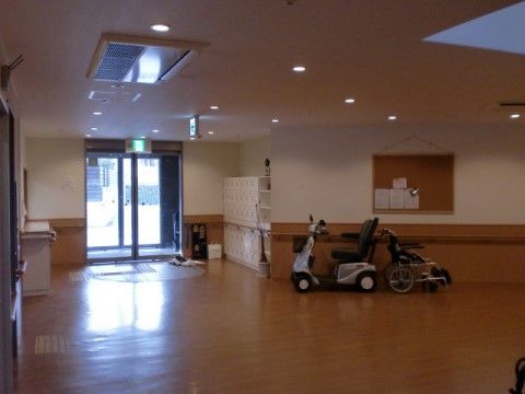 玄関はガラス張りの二重ドアを採用し、左側に受付窓口を設けている。天井には、小さな円形の照明が間隔を置いて沢山並んでいる。