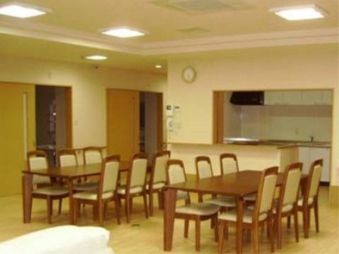 部屋の中央には木製のテーブルが二つと複数の椅子が置かれている。天井にはエアコンがあり快適にお過ごしいただける。