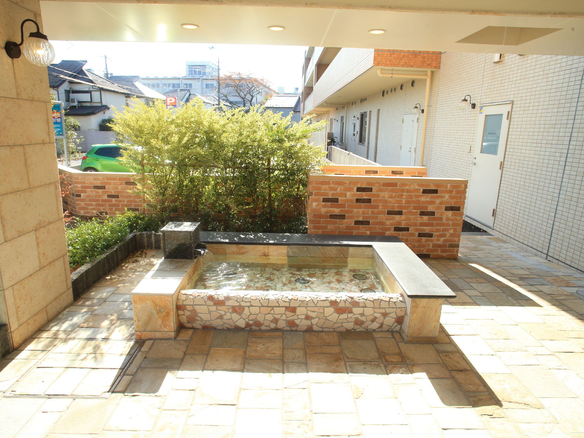 エントランスの左側には足湯が設置されており、入居者や関係者が利用することができる。足湯は岩で作られている。